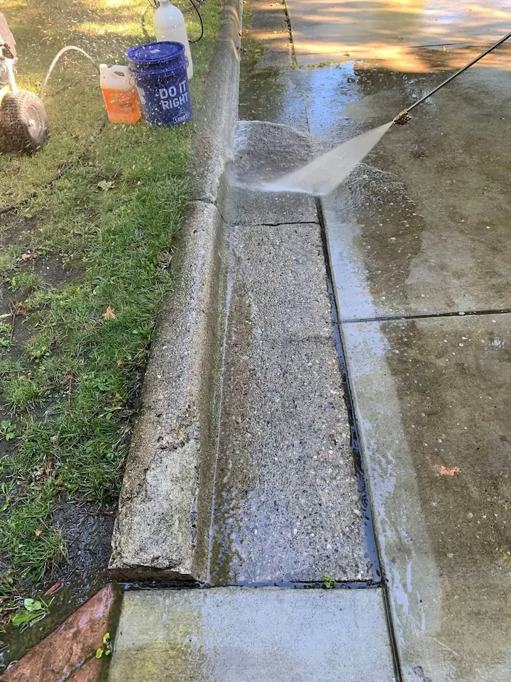 A curb being pressure washed